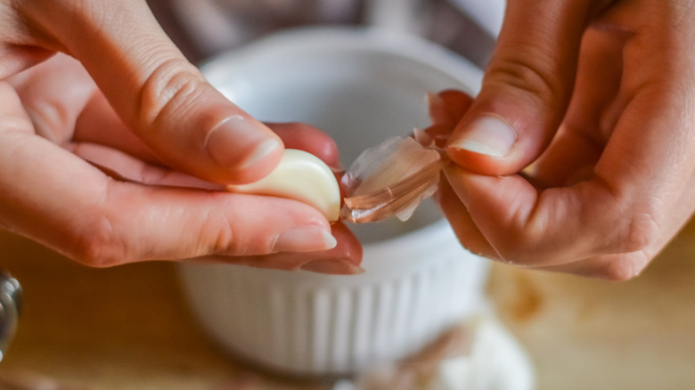 Hands peeling garlic clove