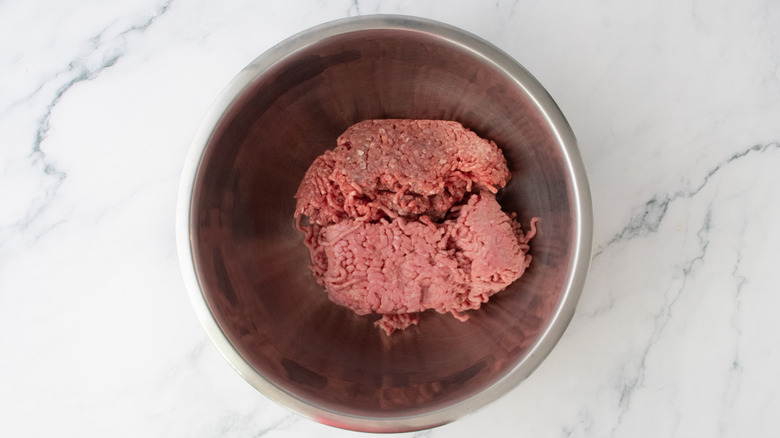 A large bowl filled with two types of ground meats