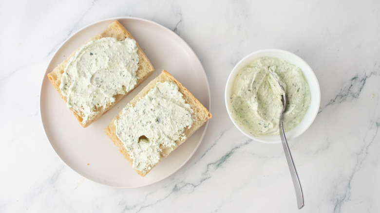 A portion of loaf-style bread spread with a creamy condiment