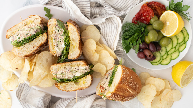 Overhead shot of Mediterranean tuna salad sandwiches with salad ingredients on the side.