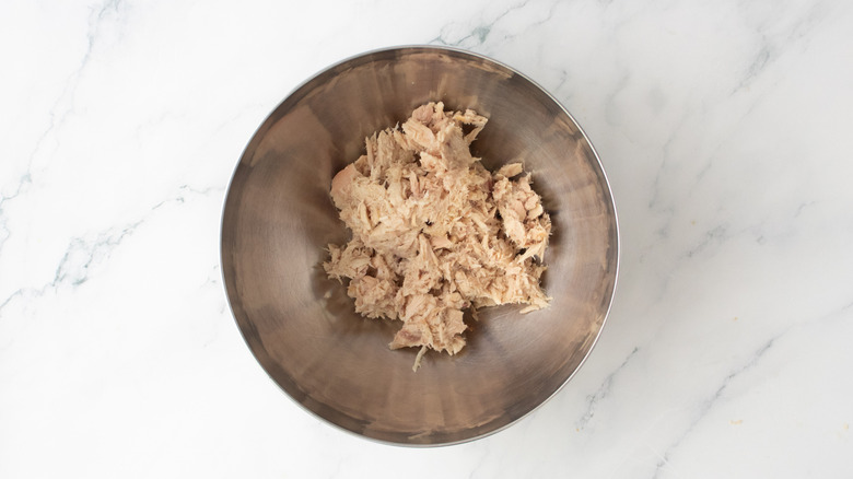 Canned tuna in a large metal bowl