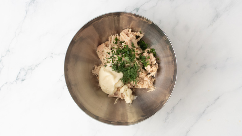 Tuna in a metal bowl with mayonnaise and seasonings