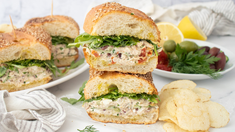 Side shot of tuna salad sandwiches with topping ingredients on the side