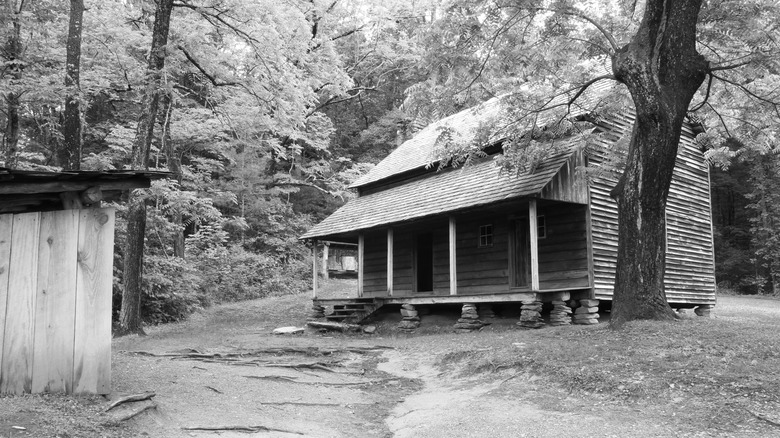 Biscuits and gravy on blue plate next to sausage.