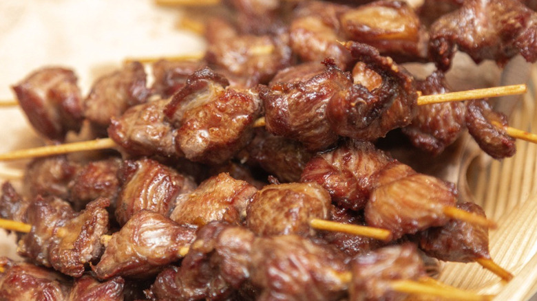 A stack of chislic meat skewers, looking freshly cooked.