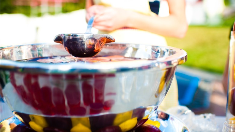 A punch bowl with scoop at an outdoor setting