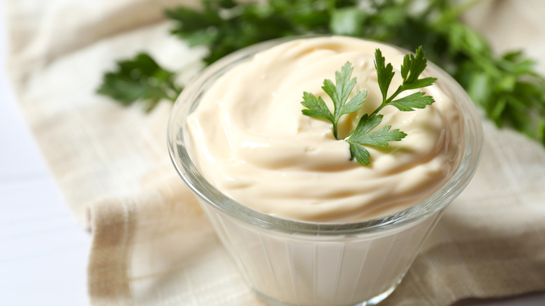 Glass bowl of mayonnaise with parsley