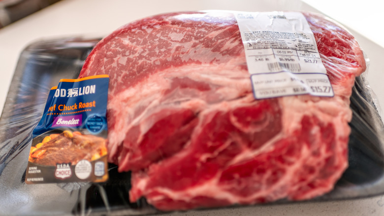 A beef chuck roast wrapped in plastic from a supermarket.
