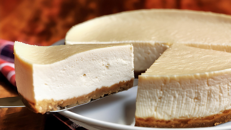 a cheesecake slice being cut