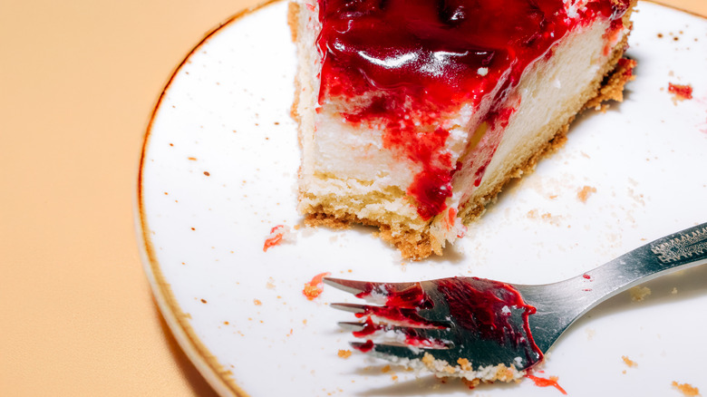 a cheesecake topped with fruit on a plate with a fork