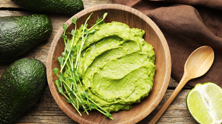 Wooden bowl of a green avocado dip