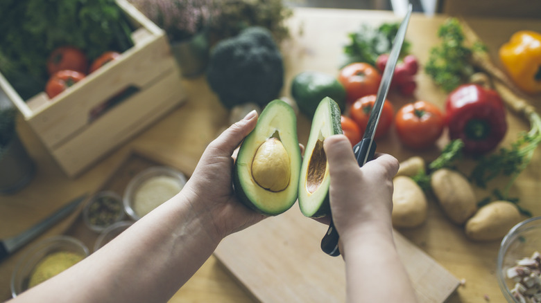 person holding cut avocado