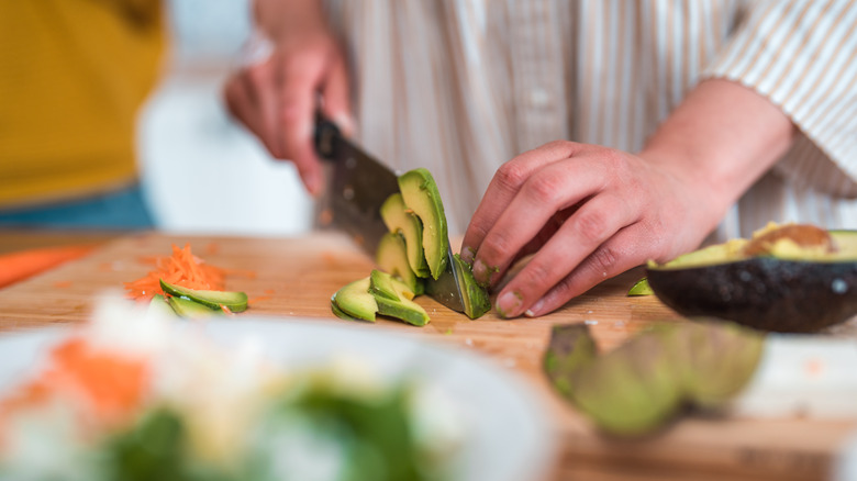 person slicing avocado
