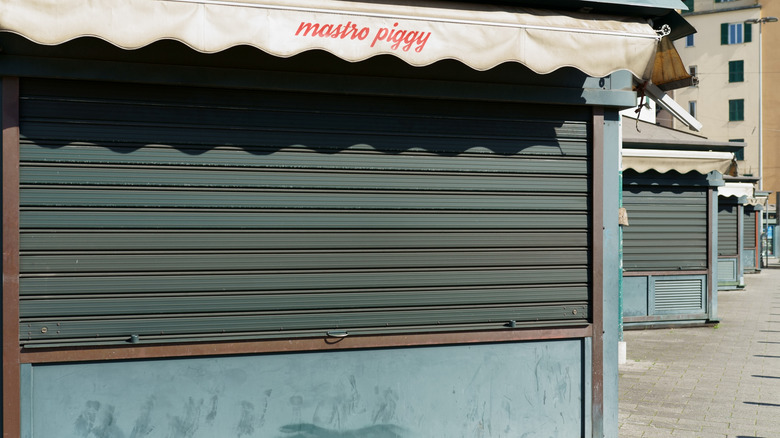 A line of outdoor eateries that are all closed.