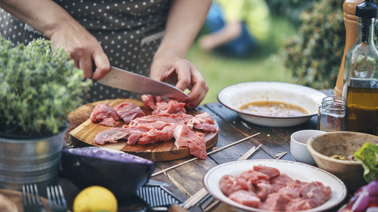 Person cutting beef to submerge in marinade