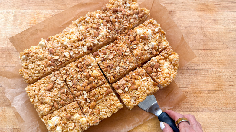 hand with spatula under cut bars