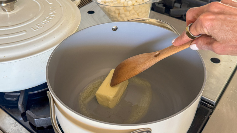 hand stirring butter in pot