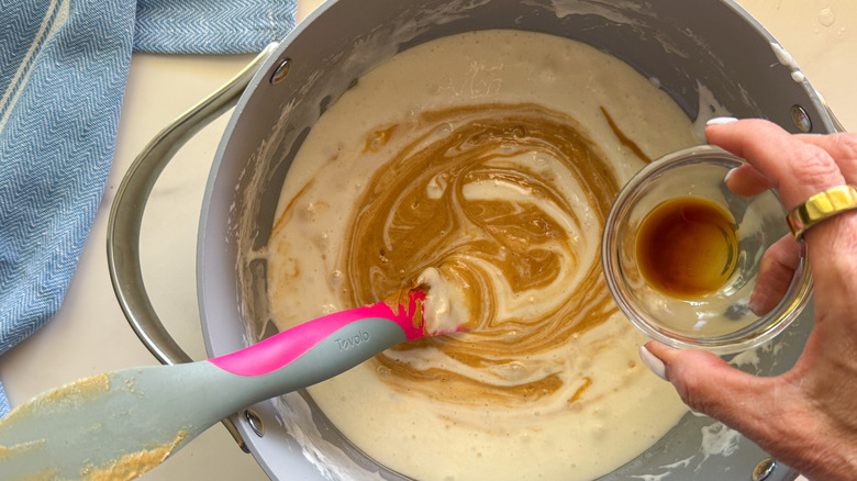 hand adding vanilla to pot
