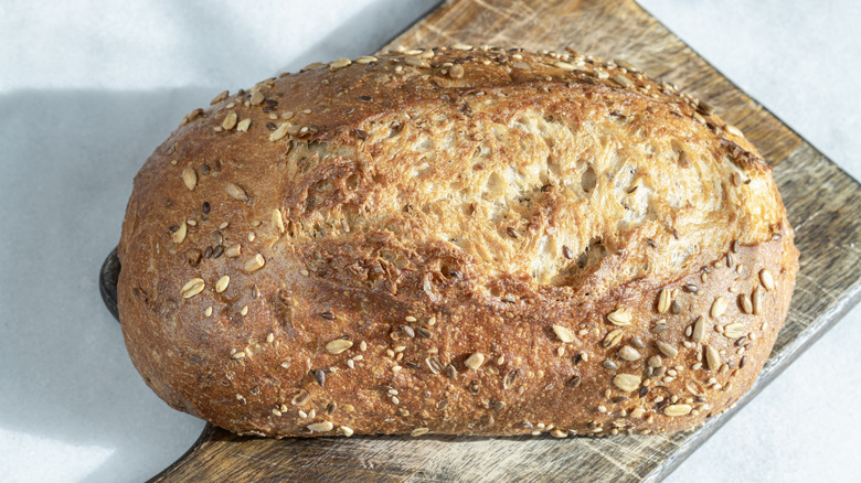 Loaf of sunflower bread on a wooden cutting board