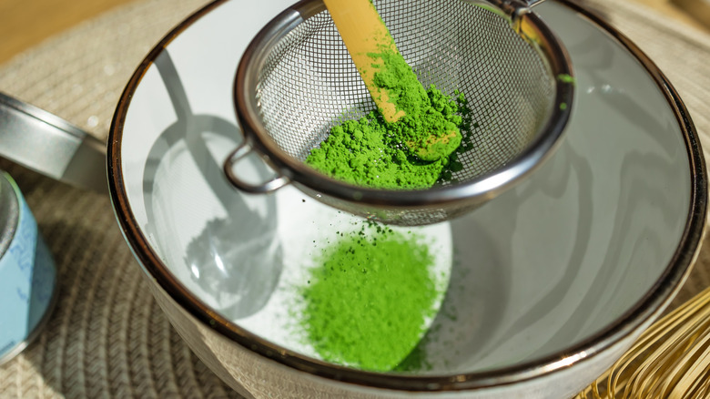 Sifting matcha powder into bowl