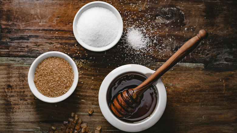 bowls of sugar and honey on wooden table