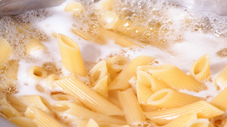 Crowded penne pasta boiling in water