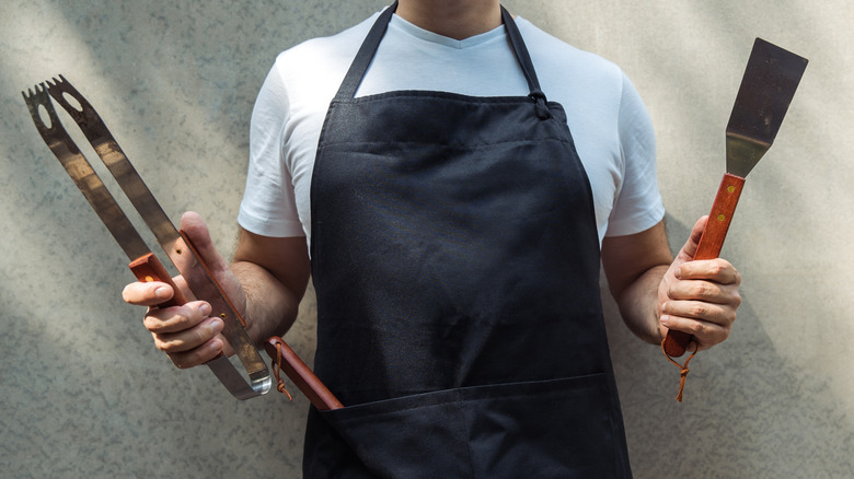 Cook holding utensils