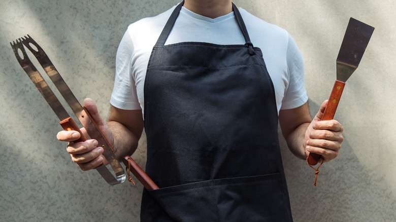 Cook holding utensils