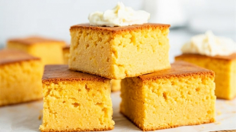 A stack of golden cornbread topped with butter.