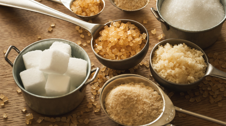 Various kinds of sugars are arranged in measuring cups
