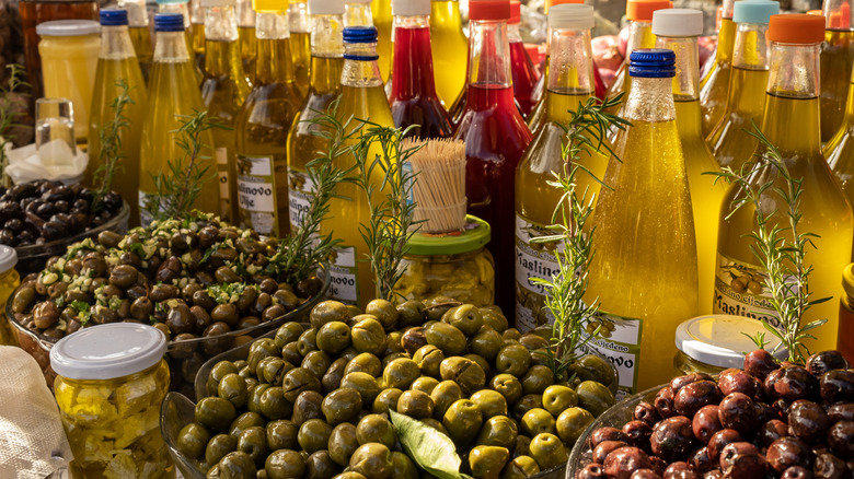 An olive oil festival table with bottles of olive oil and plates of olives in Bar, Montenegro.
