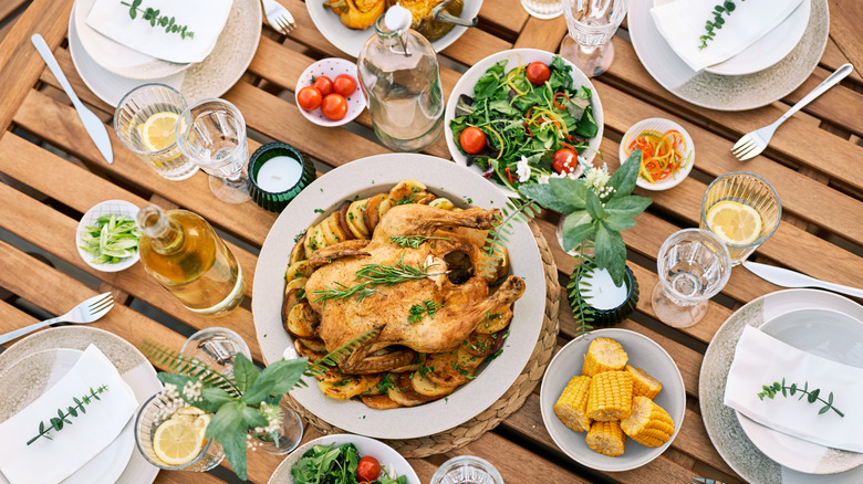 A flat lay of an outdoor meal with chicken as the main course