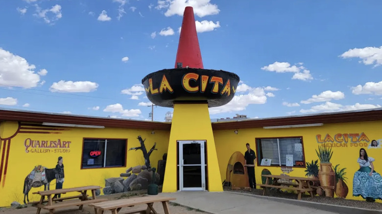 A yellow restaurant exterior with a giant red and black sombrero above the front door.