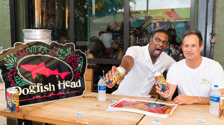 Two men posing with beers at a Dogfish Head bar