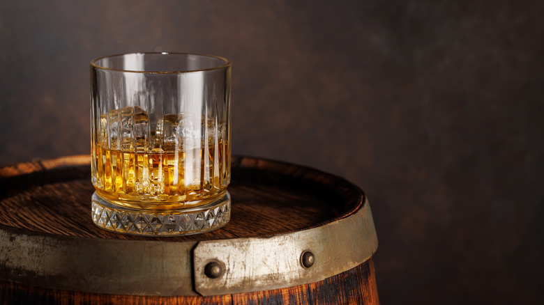 Glass of scotch on a barrel