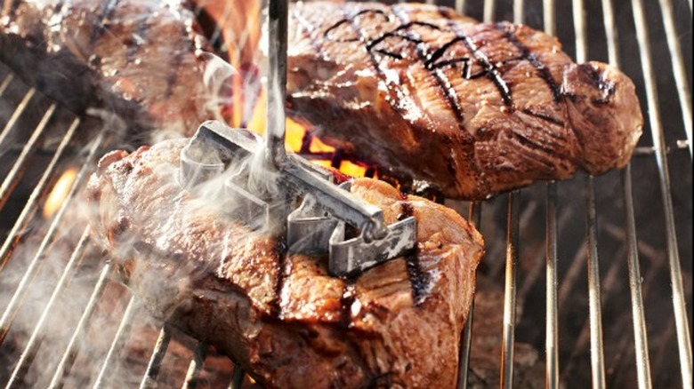 Multiple steaks on grill with brander