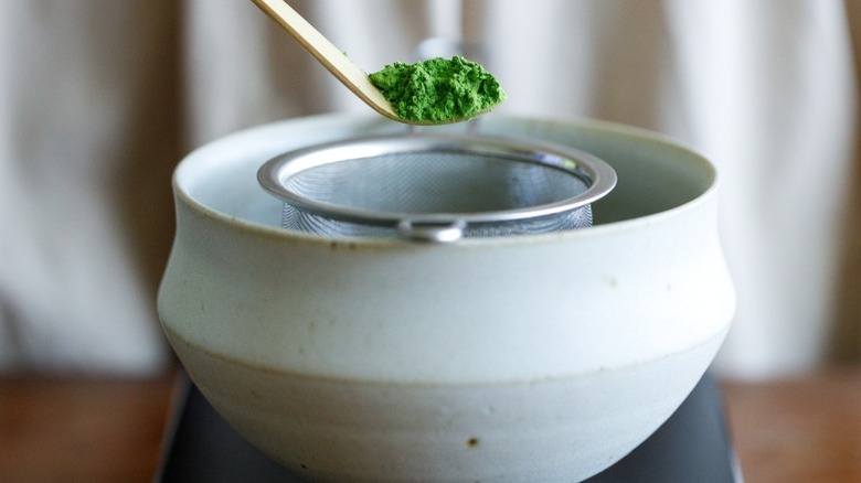 Scooping matcha powder into bowl