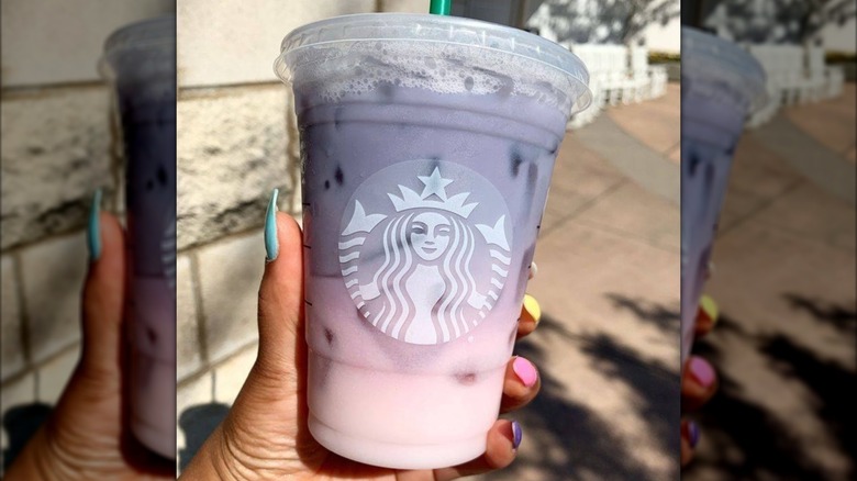 Person's hand holding the Starbucks Purple Drink