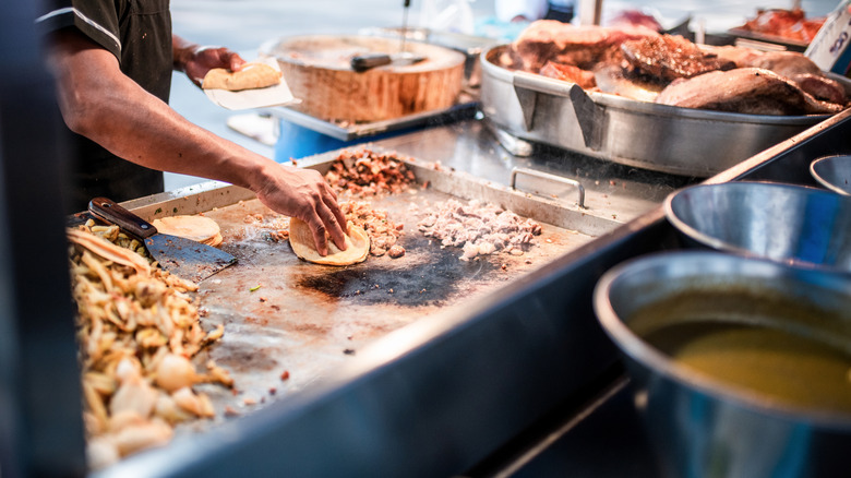 Mexican street food vendor preparing tacos