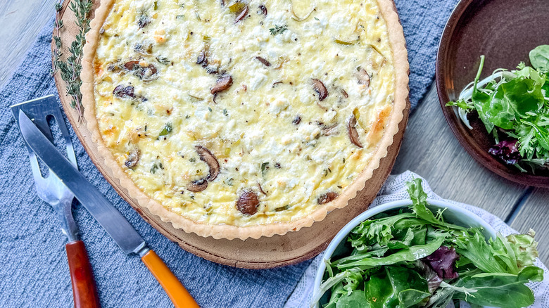 Mushroom and Leek Quiche on table with salad