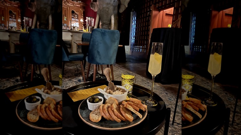 A cocktail in a champagne flute and plate of salmon dip at Unlisted speakeasy in Seattle.