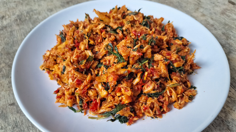 Pulled chicken with herbs on a white plate
