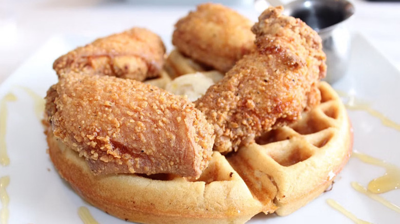 Four chicken wings on top of a waffle from Wings N Waffles