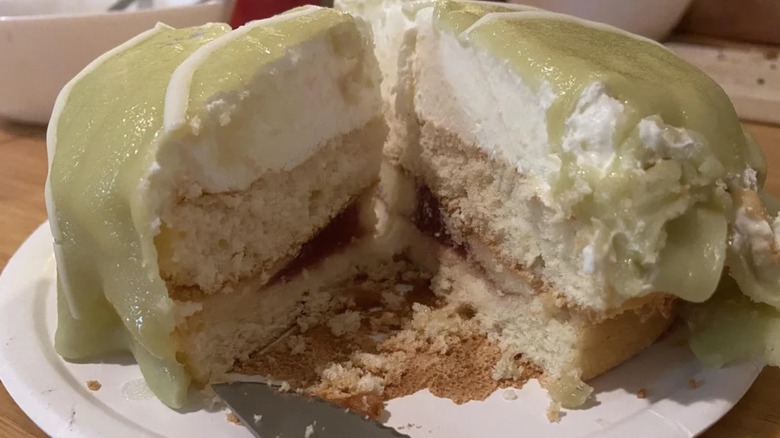 Trader Joe's Swedish Princess Rasberry Cake with green cream on top, already missing a slice