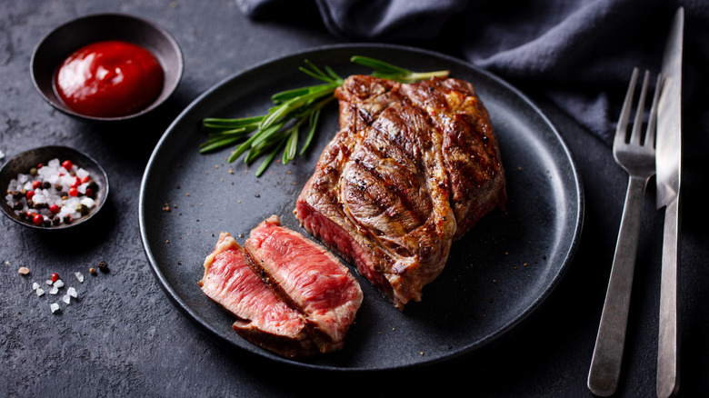 Medium rare steak on a black plate