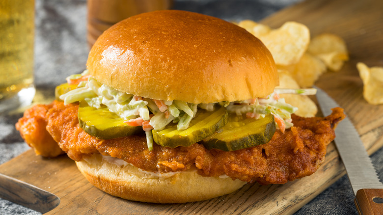 A Nashville hot fish sandwich is served with potato chips