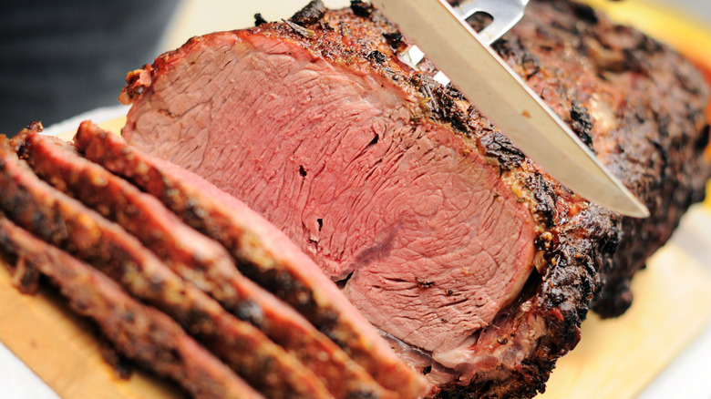 Sliced prime rib on a wooden cutting board