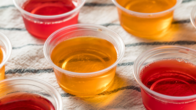 red and orange Jell-O shots in short plastic cups