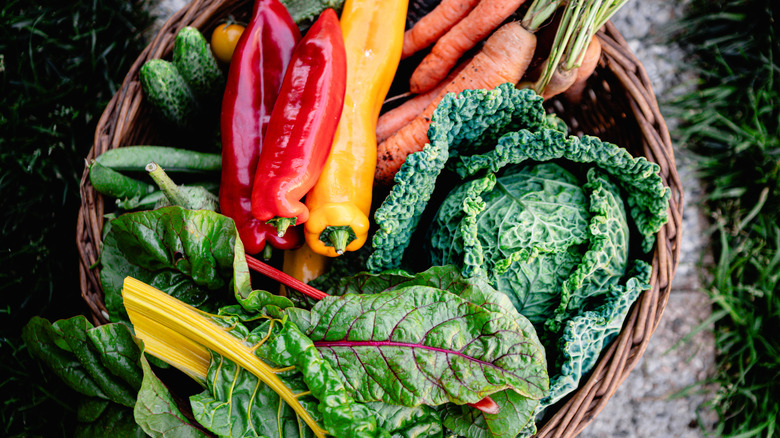 Carrots, kale, and peppers in basket.