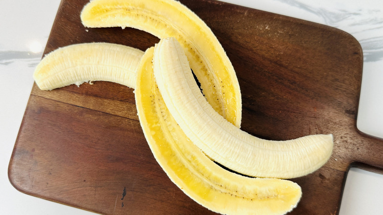 Halved bananas on cutting board